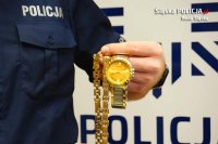 Policjant prezentuje biżuterię którą wręczył oszust