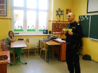 Policjant w klasie prezentuje odblaski