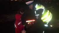 Policjant przekazuje odblaskową opaskę