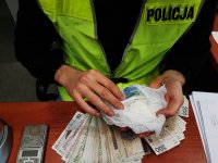 Policjant liczy zarekwirowane pieniądze