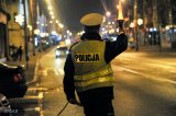 Policjant z drogówki z latarką wskazuje sygnał do zatrzymania