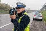 policjant drogówki wykonuje pomiar prędkości - zdjęcie poglądowe