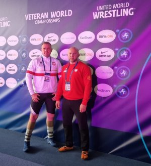 dwóch mężczyzn w tym Krzysztof Czerczak pozuje do zdjęcia na tle baneru mistrzostw